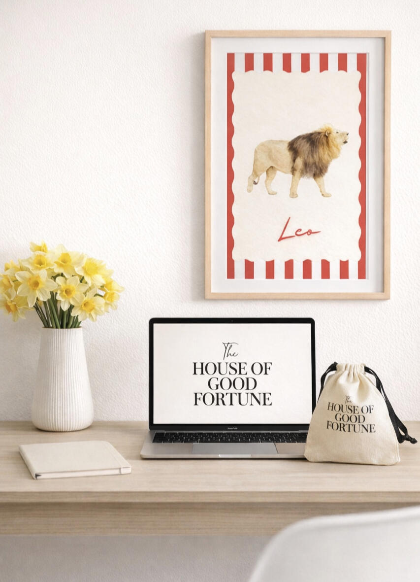 The House of Good Fortune Office A desk with a laptop, Zodiac picture and The House of Good Fortune pouch